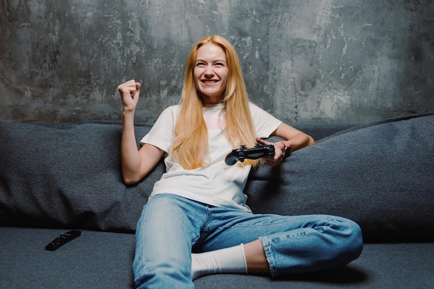 Foto eine junge frau, die eine spielkonsole spielt und online mit freunden feiert, wie sie ein spiel gewinnt