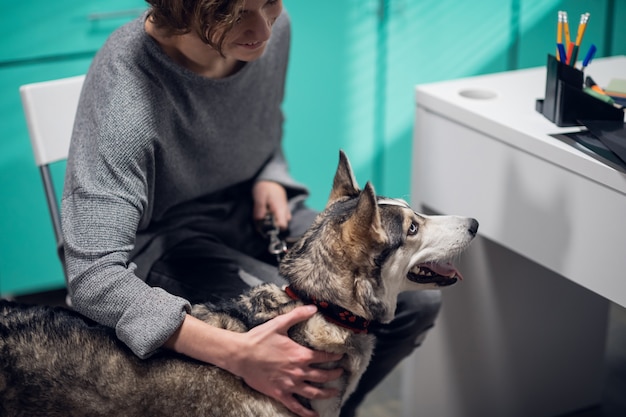 Eine junge Frau, die ihren Hund zur Untersuchung in eine Tierklinik bringt.