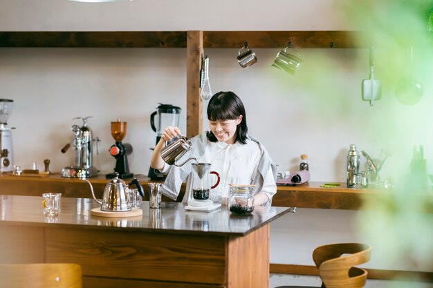 Eine junge Frau, die in einem entspannenden Raum Kaffee brüht