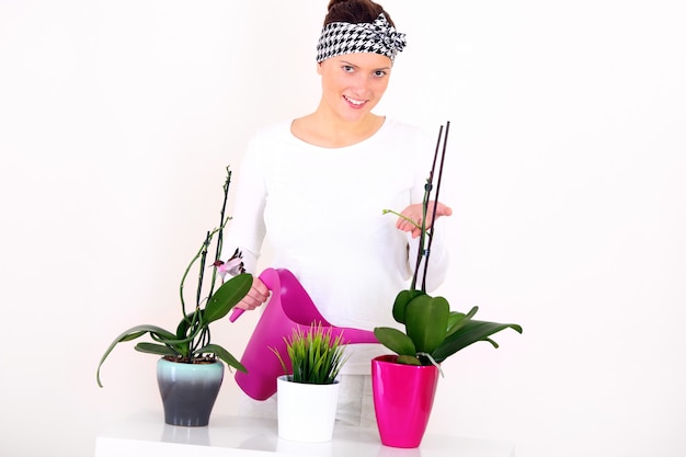 eine junge Frau, die Pflanzen gießt
