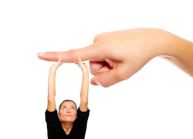 Foto eine junge frau, die sich an einem großen finger auf weißem hintergrund festhält