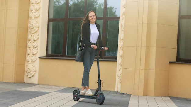 Eine junge Frau fährt mit einem Elektroroller in der Stadt Umweltfreundlicher Transport