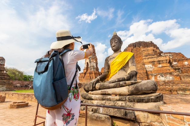 Eine junge Frau geht in den alten Tempel in Phra Nakhon Si Ayutthaya, Thailand an einem entspannenden Tag.