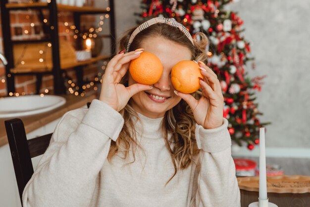 Eine junge Frau hält eine Orange in den Händen in der Nähe ihrer Augen. Gesundes Essen und Lifestyle-Konzept