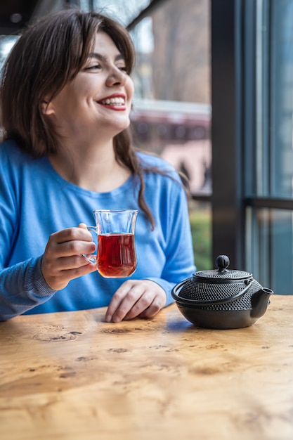 Eine junge Frau in einem Café trinkt türkischen Tee