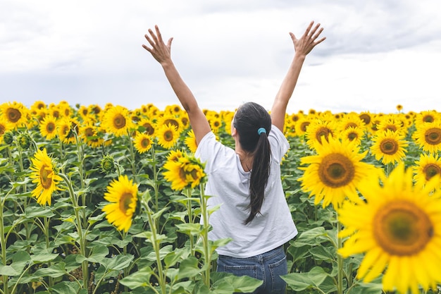 Eine junge Frau in einem Feld mit vielen Sonnenblumen