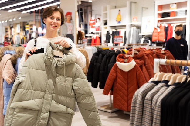 Eine junge Frau kauft während eines Verkaufs in einem Bekleidungsgeschäft ein