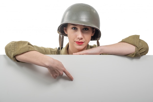 Eine junge Frau kleidete in der amerikanischen Militäruniform ww2 an, die leeres leeres Schild zeigt