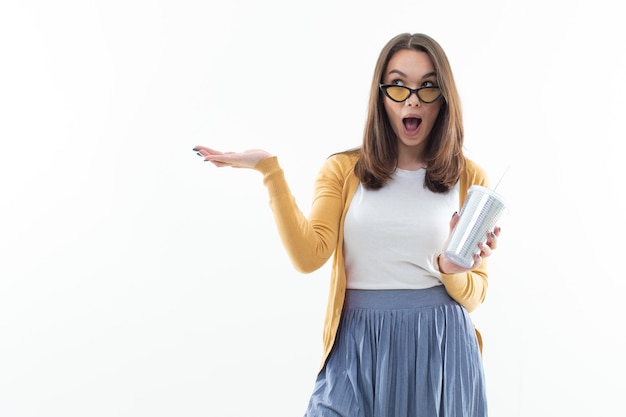 Eine junge Frau mit einem glänzenden Glas Limonade auf weißem Hintergrund Coole Stimmung SommergetränkeCopy Space