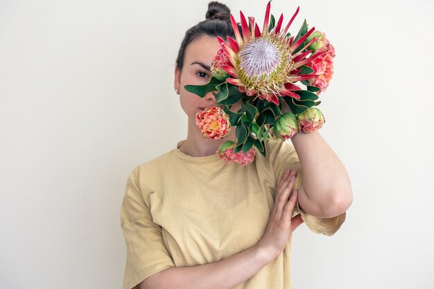 Eine junge Frau mit Protea-Blume auf weißem Hintergrund