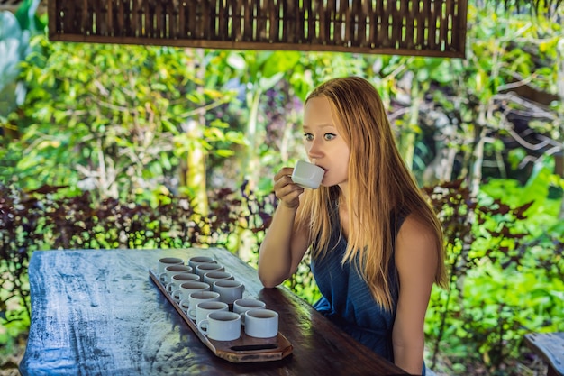 Eine junge Frau probiert verschiedene Kaffee- und Teesorten, darunter Kaffee Luwak.