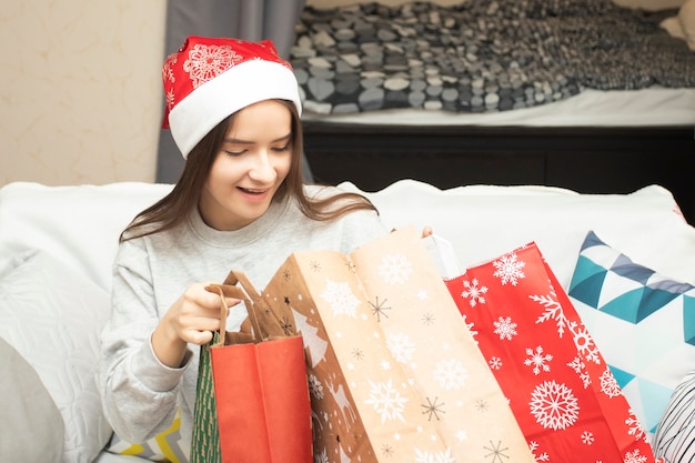 Eine junge Frau schaut mit Geschenken in eine Tasche