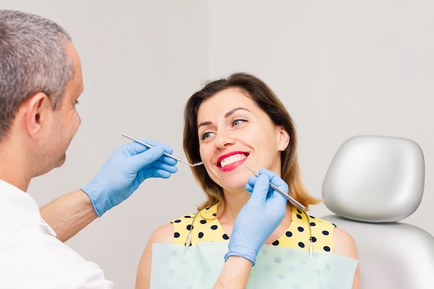 Eine junge Frau sitzt in der Zahnarztpraxis.