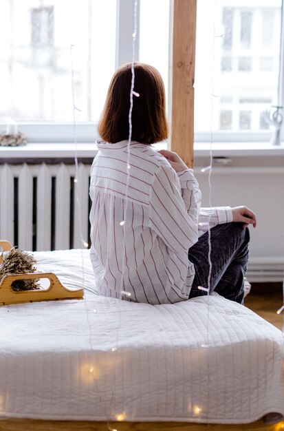 Eine junge Frau sitzt mit dem Rücken zur Kamera Einsamkeit Stress und Verzweiflung Konzept Foto