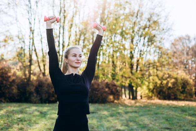 Foto eine junge frau treibt im freien sport. mädchen mit blonden haaren trainiert im park auf der natur.