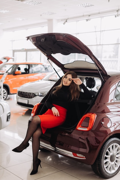 Eine junge Frau wählt ein neues Auto im Autohaus