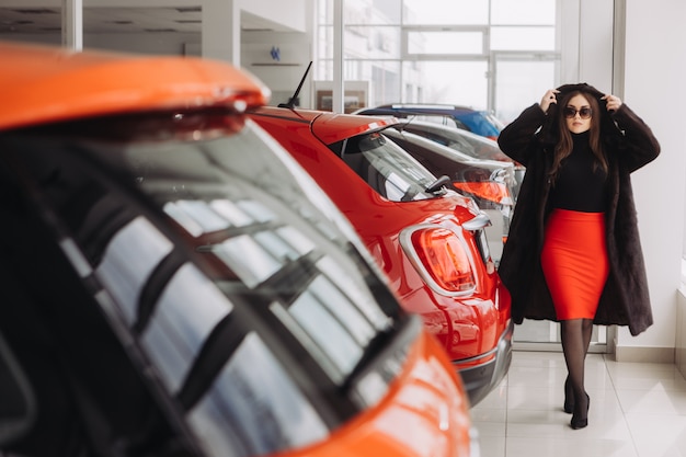 Eine junge Geschäftsfrau testet Autos in einem Autohaus