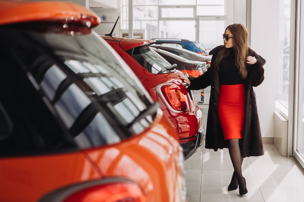 Eine junge Geschäftsfrau testet Autos in einem Autohaus