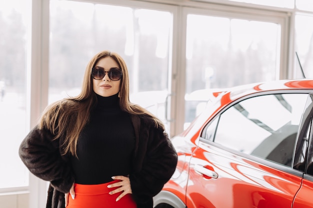 Eine junge Geschäftsfrau testet Autos in einem Autohaus