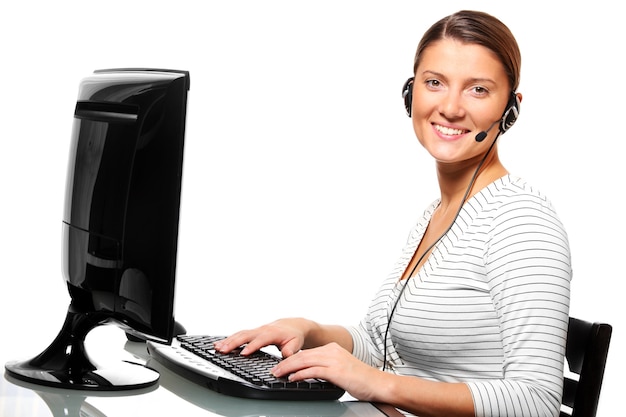eine junge hübsche frau im büro mit einem headset auf weißem hintergrund