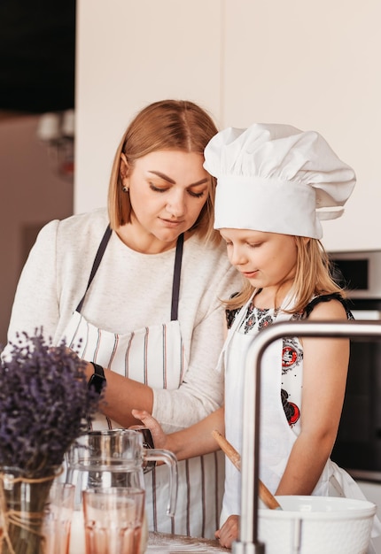 Eine junge Mutter bringt ihrer Tochter das Kochen in der Küche bei. Zeit mit der Familie