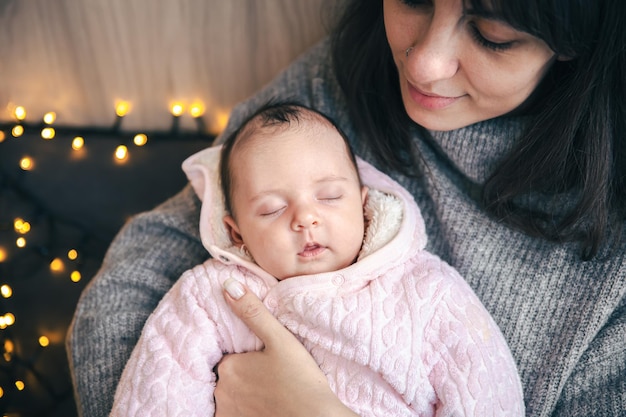 Eine junge Mutter mit einem neugeborenen Mädchen im Arm