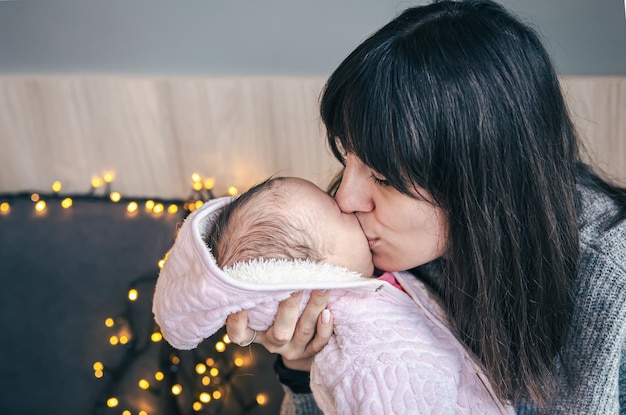 Eine junge Mutter mit einem neugeborenen Mädchen im Arm