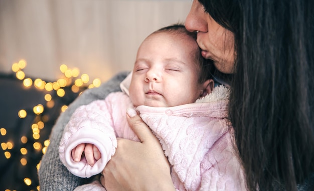 Eine junge Mutter mit einem neugeborenen Mädchen im Arm