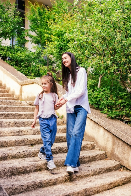 Eine junge Mutter mit einer kleinen Tochter geht die Treppe hinunter.