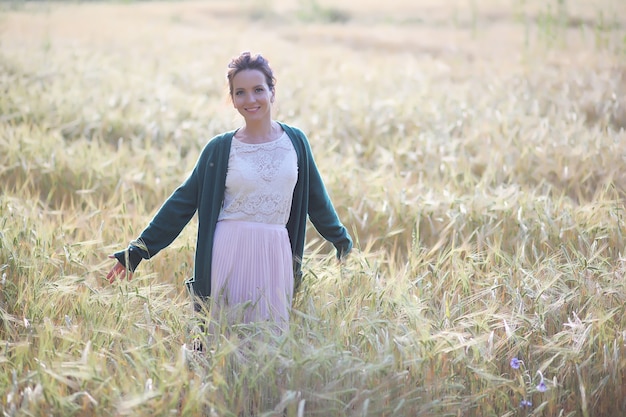 Eine junge Mutter mit ihrer Tochter bei einem Spaziergang in den Weizenfeldern