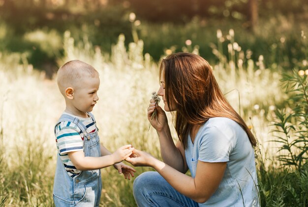 Eine junge Mutter spielt im Sommer mit ihrem kleinen Sohn im Park