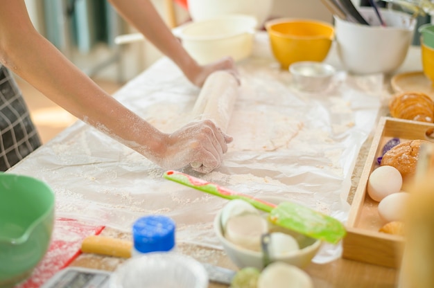 Eine junge schöne Asiatin backt in ihrem Küchen-, Bäckerei- und Café-Geschäft