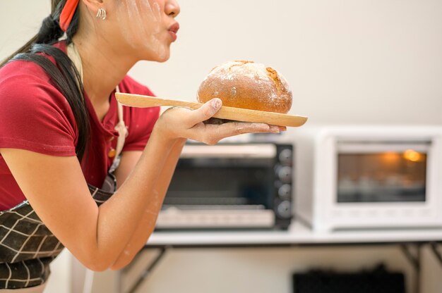 Eine junge schöne Asiatin backt in ihrem Küchen-, Bäckerei- und Café-Geschäft