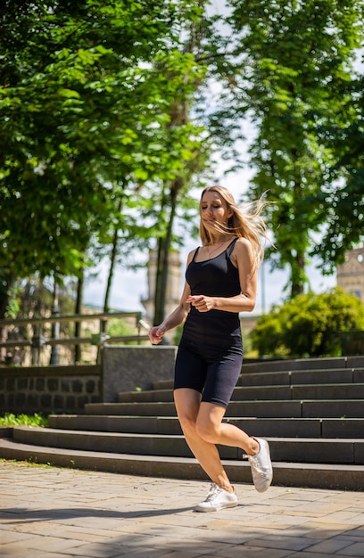 Eine junge schöne blonde Frau mit sportlichem Körperbau in einem schwarzen T-Shirt