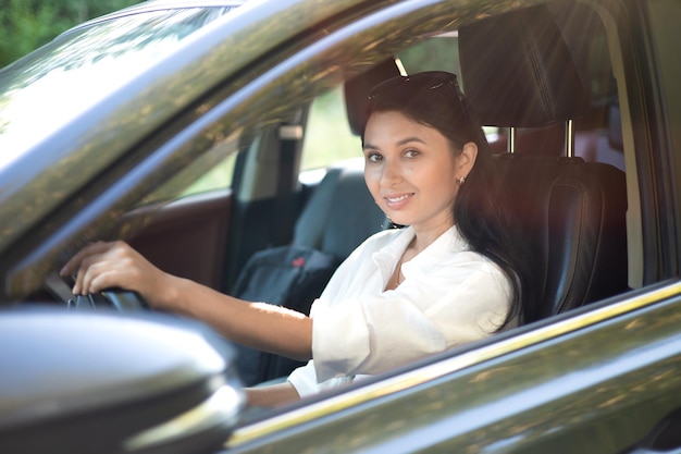 Eine junge schöne Fahrerin sitzt hinter dem Lenkrad ihres Autos Eine moderne Dame Eine Reise eine Reise Lifestyle