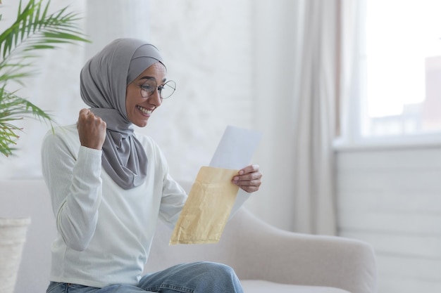 Eine junge schöne moslemische frau liest einen glücklichen brief nach hause arabischer student erhielt bestätigung von der