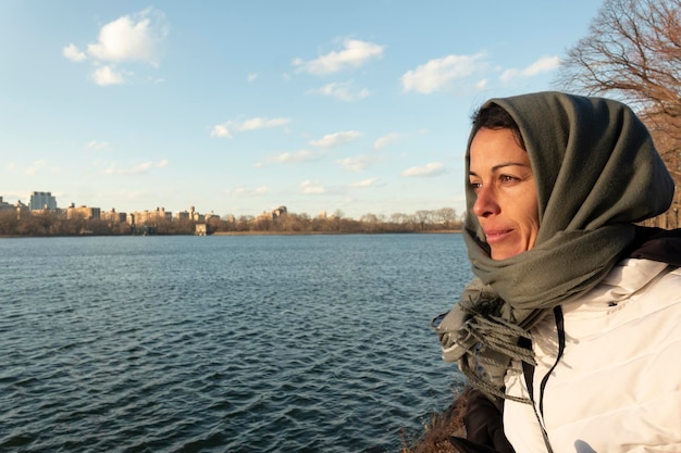 Eine junge Schönheit mit Kopftuch blickt gelassen auf den menschenleeren New Yorker Hudson River.