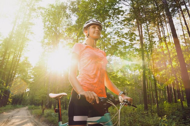 Eine junge Sportlerin in einem Helm und einem orangefarbenen T-Shirt während eines Outdoor-Trainings