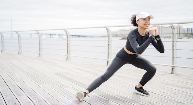 Eine junge Sportlerin macht aktive Fitnessübungen mit Yoga-Elementen Lifestyle misst mit einer Fitnessuhr und einem Tracker ihren Puls