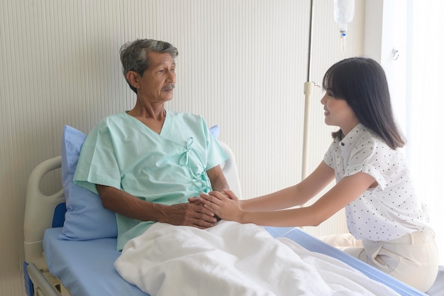 Eine junge Tochter besucht den kranken alten Vater im Krankenhaus und im medizinischen Konzept