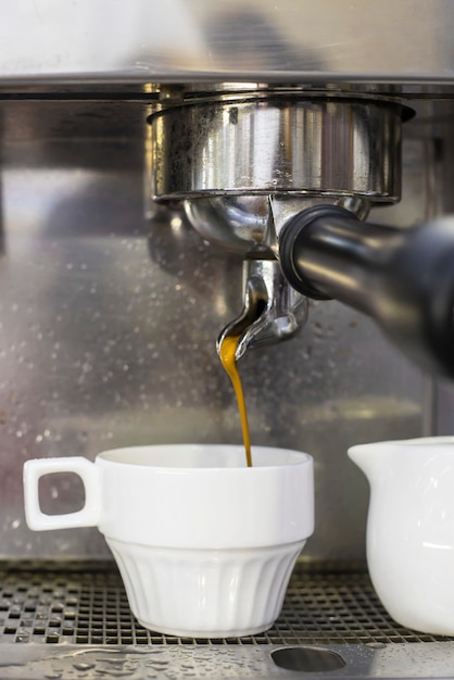 Eine Kaffeemaschine bereitet zwei Espresso in zwei Glastassen in einem Café zu