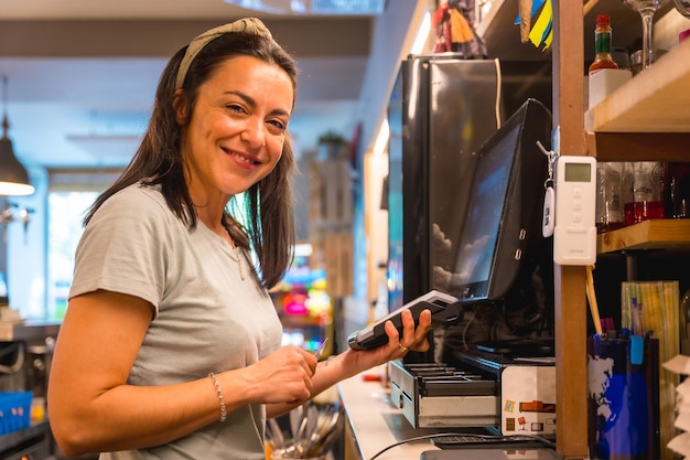 Eine Kellnerin, die das Café per Karte auflädt