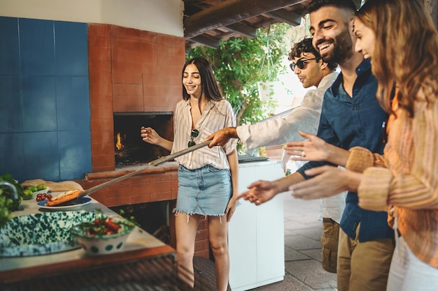 Foto eine kindergruppe trifft sich am wochenende zum gemeinsamen feiern im innenhof und backt gemeinsam pizzen. junge italiener bereiten im sommer pizzen auf der terrasse zu