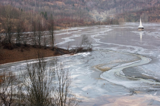 Foto eine kirche, die von giftigem abwasser aus dem goldminen-dekantationssee geamana in rumänien untergetaucht ist