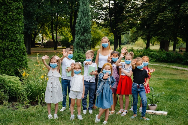 Eine Klasse maskierter Schulkinder trainiert während der Epidemie im Freien. Zurück in die Schule, Lernen während der Pandemie.