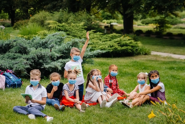 Eine Klasse maskierter Schulkinder trainiert während der Epidemie im Freien