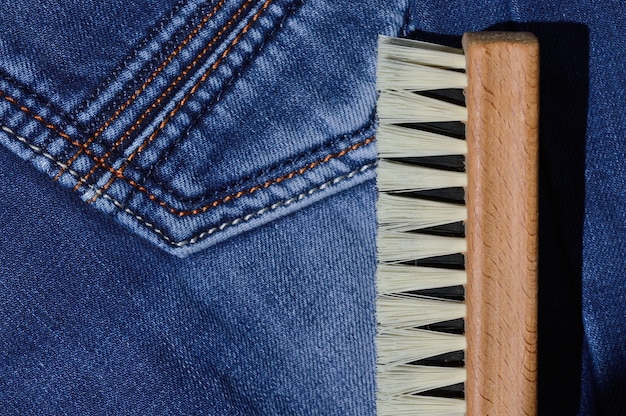 Eine Kleiderbürste liegt auf gefalteten Jeans