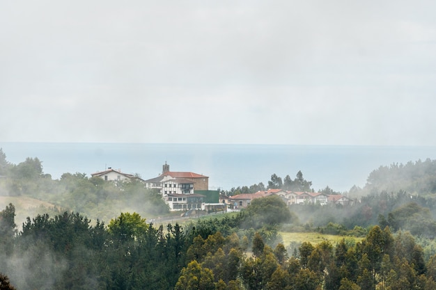 Eine kleine Stadt auf dem Gipfel des Berges voller Nebel