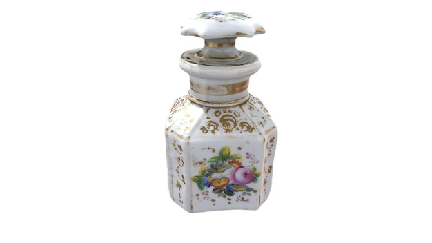Eine kleine weiß-goldene Flasche mit einem Blumenmuster auf der Oberseite.