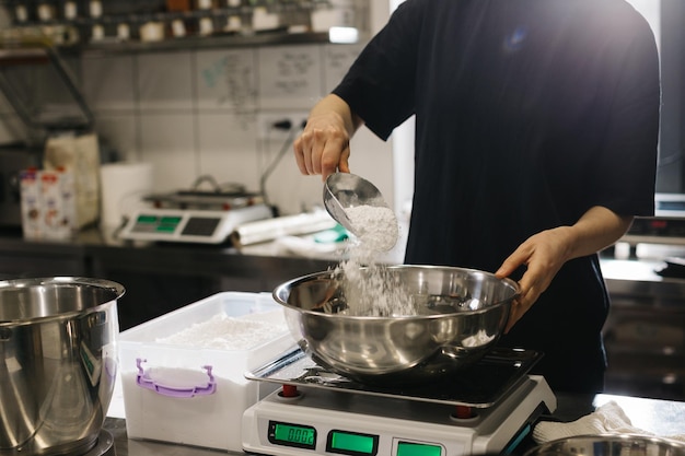 Eine Köchin arbeitet in einer modernen Industrieküche Der Prozess der Kuchenherstellung in einer Bäckerei oder einem Café